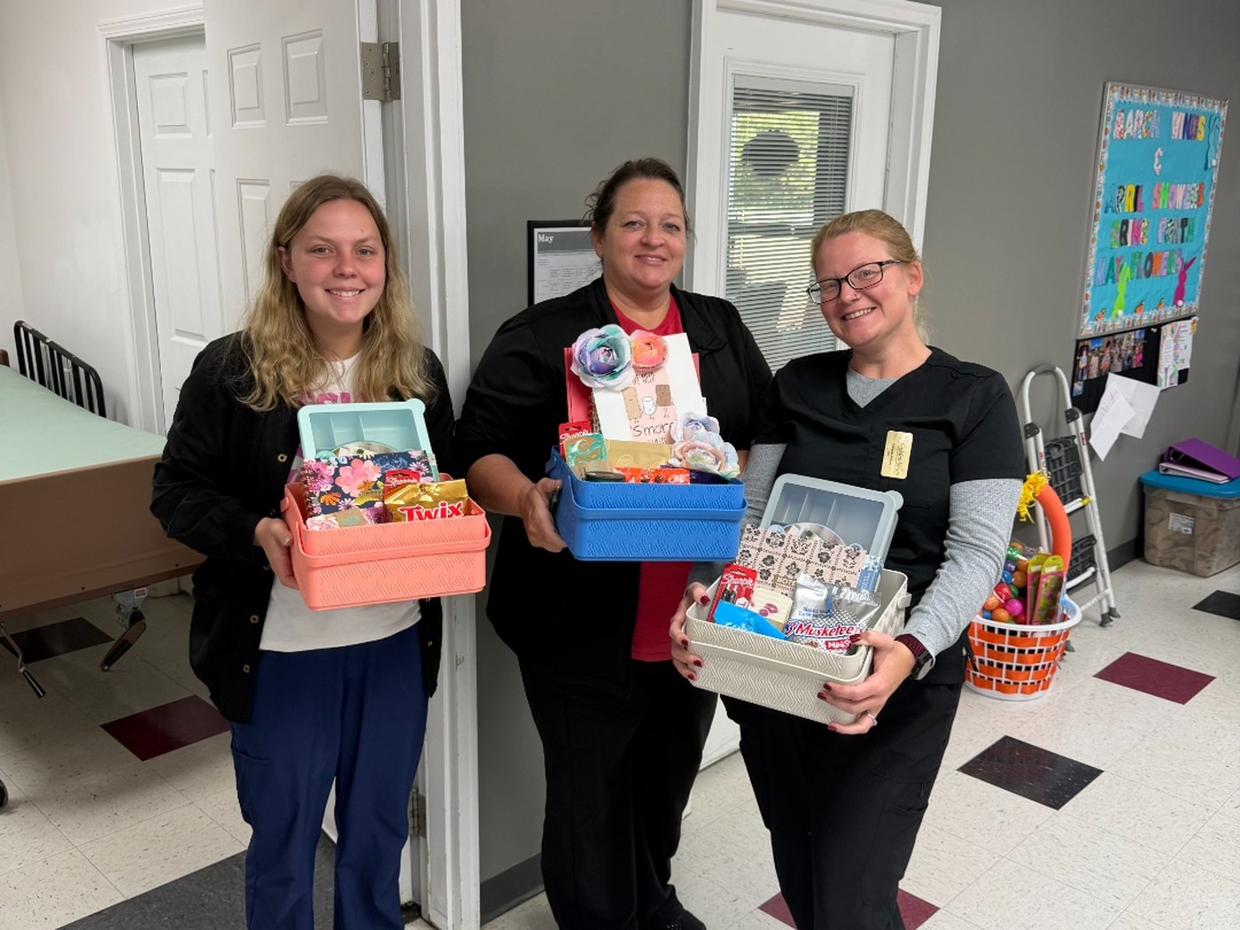 Smiling Golden Years team members holding gift baskets at the center